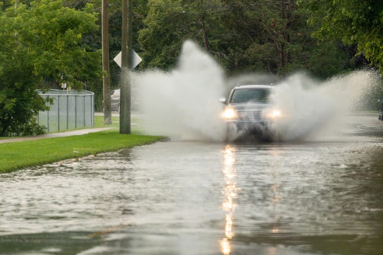 Car travelling through flood after extreme rain