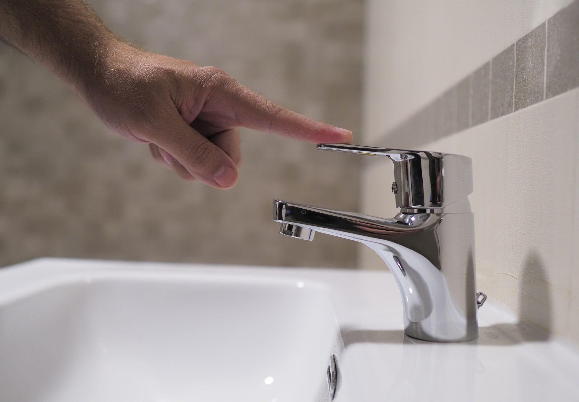 Save water. Volunteer keeps turning off the running water in the bathroom to protect environment.